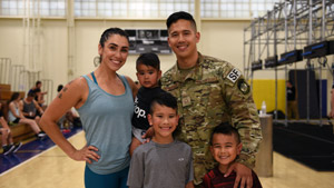 Smiling family posing together on a basketball court